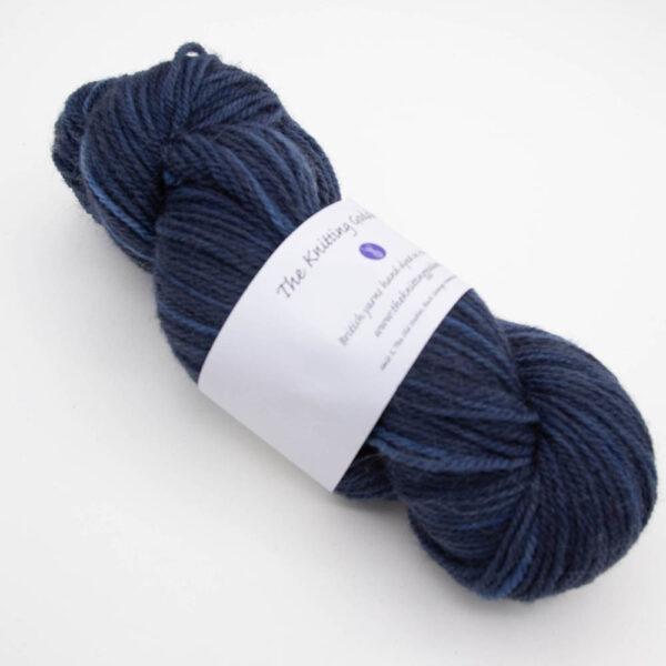 skein of navy DK sock wool with The Knitting Goddess ball band