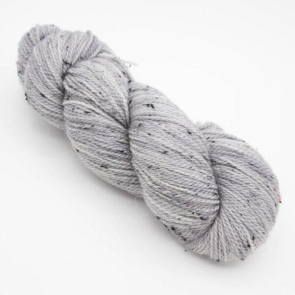 skein of pale grey pearl tweed yarn with dark flecks