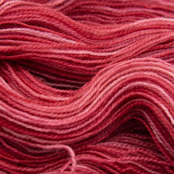 close up of red Bluefaced Leicester and nylon yarn which has a high twist