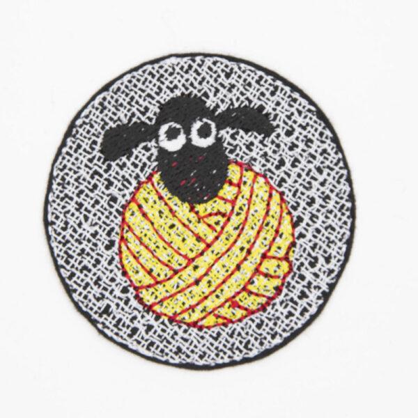 embroidered patch of sheeps head on a ball of yellow yarn