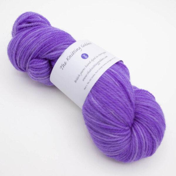 skein of violet DK sock wool with The Knitting Goddess ball band