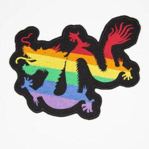 Embroidered patch with chinese style dragon on a black felt background. The dragon is split into six stripes and the colours of these form a rainbow.