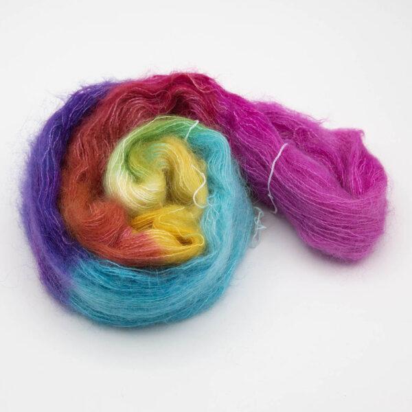 Fluffy moonbroch yarn dyed in rainbow colours. The skein is wound into a spiral