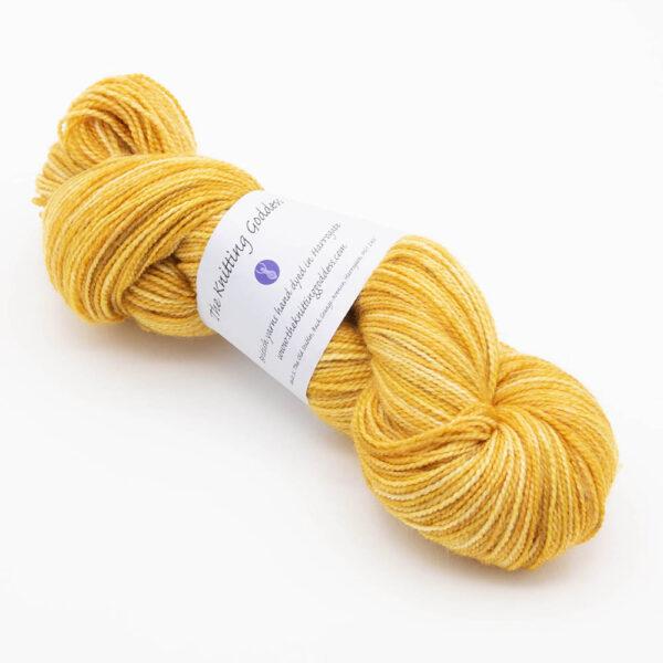 skein of hand dyed gold yarn with The Knitting Goddess ball band.