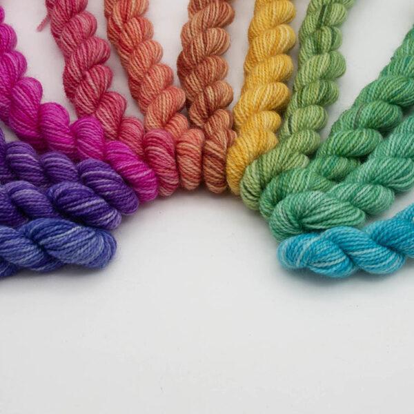 set of 12 mini skeins dyed in a hues colour wheel arranged in a curve