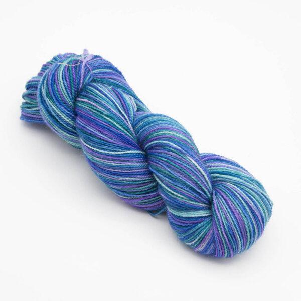 skein of hand dyed kingfisher yarn in blue, purple and green.