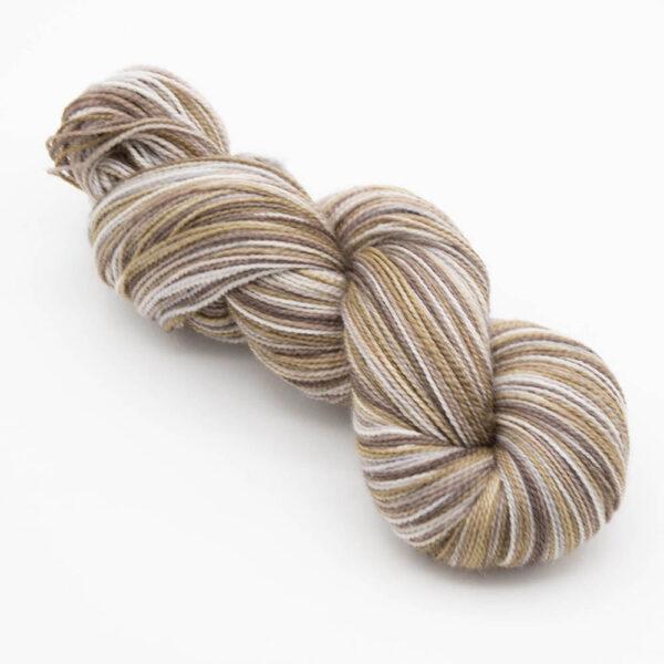 skein of hand dyed pebble yarn in brown, caramel and silver.