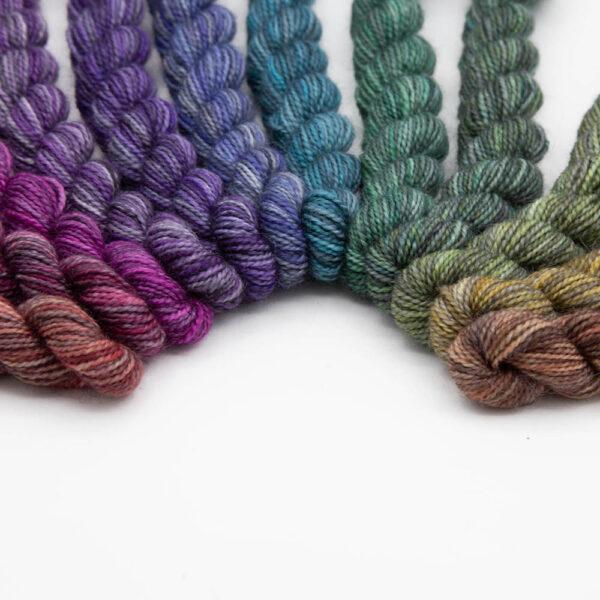 set of 12 mini skeins dyed in a shades colour wheel arranged in a curve